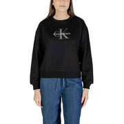 Woman wearing a black Calvin Klein long-sleeved sweatshirt and blue denim drawstring pants