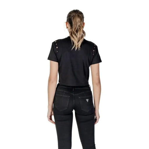 Woman wearing black crop top and jeans showcasing the Black Tie Front T Shirt with Grommets