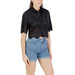 Woman wearing a black eyelet crop top and denim shorts for women’s fashion showcase