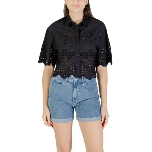 Woman wearing a black eyelet shirt and denim shorts for Women’s Black Eyelet Shirt and Denim Shorts product
