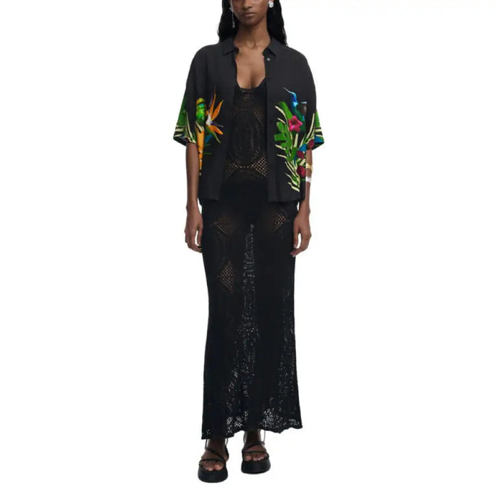Woman wearing a black floral print shirt and crochet dress showcasing stylish casual attire
