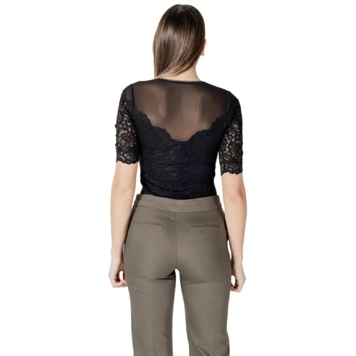 Woman wearing a black lace top and khaki pants showcasing women’s fashion style