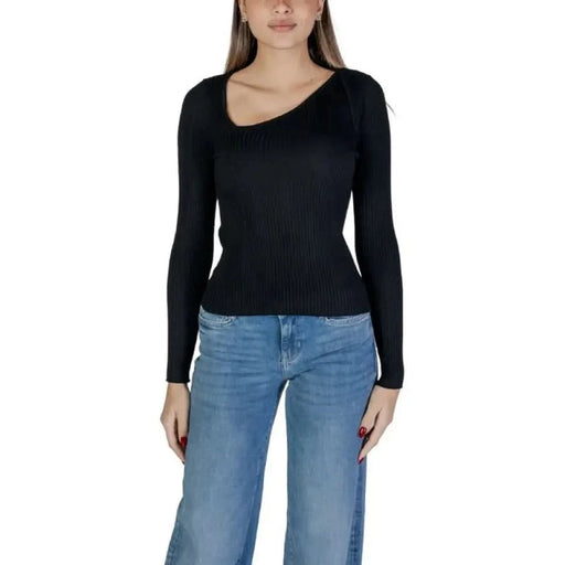 Woman in black long-sleeved asymmetrical top and blue jeans from Vila Clothes