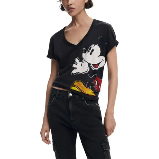 Woman wearing a black Mickey Mouse T-shirt and black cargo pants for the product display
