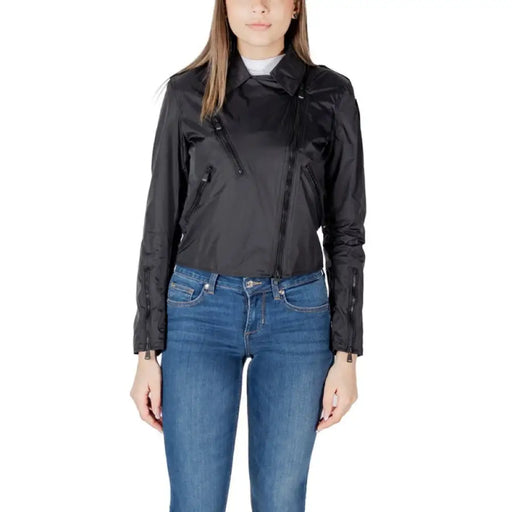 Woman wearing a black moto jacket and blue jeans showcasing fashion style