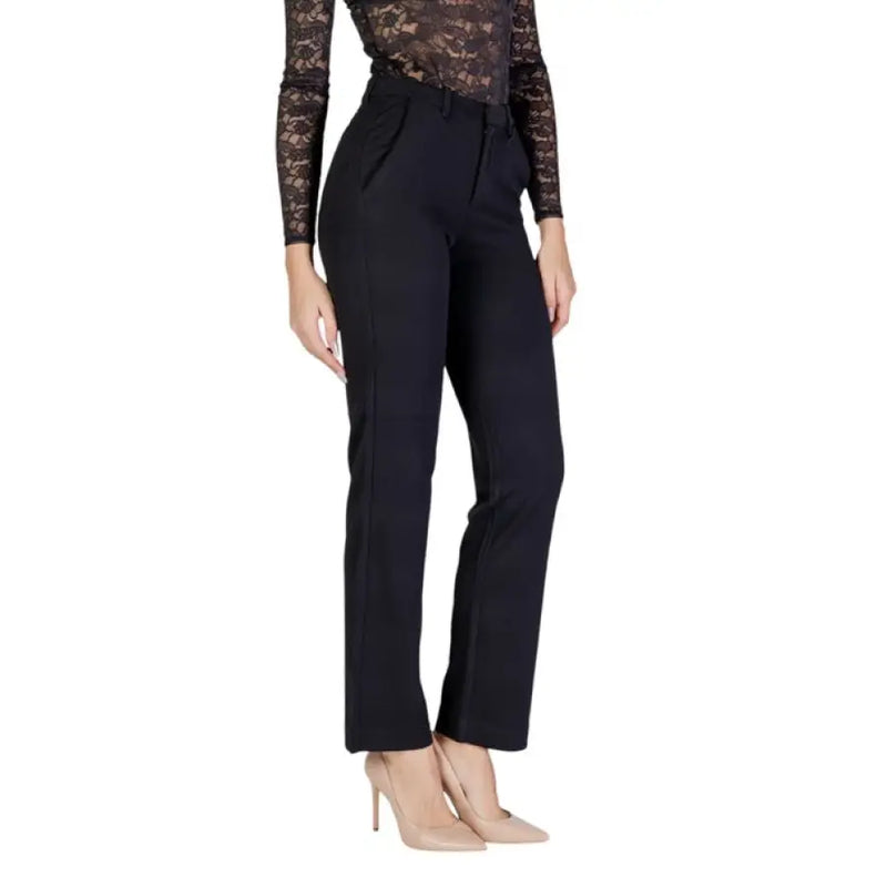 Woman wearing black dress pants and nude heels showcasing elegant style