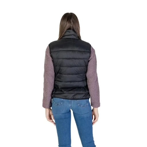 Woman in a black puffer vest from B.young with turtleneck and front pockets
