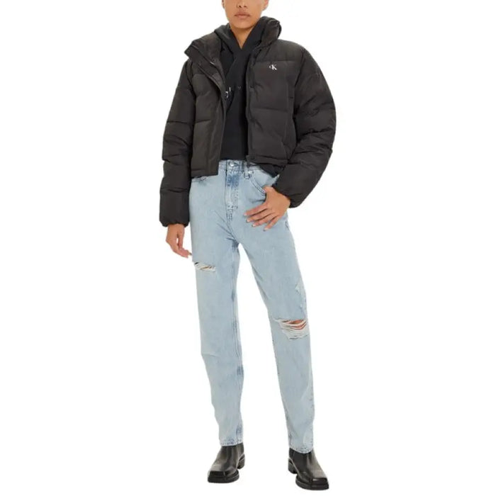 Woman wearing Black Calvin Klein Puffer Jacket with ripped jeans