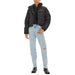 Woman wearing Black Calvin Klein Puffer Jacket with ripped jeans