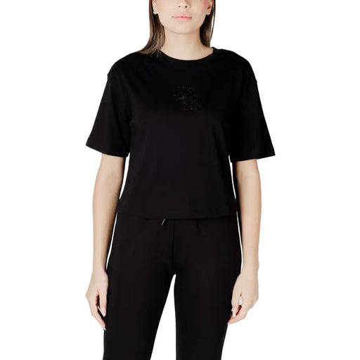 Woman in black short-sleeve T-shirt and track pants showcasing Womens White T Shirt product