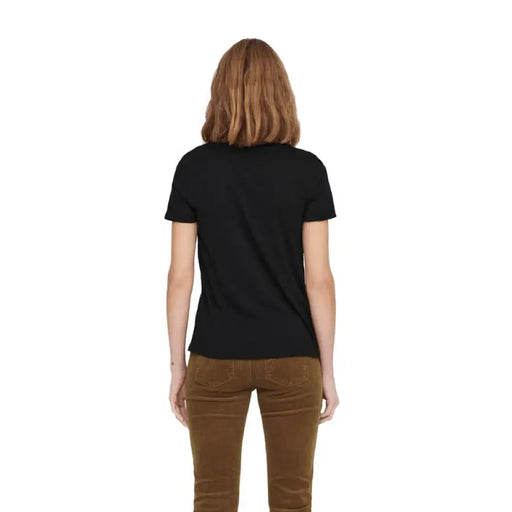 Woman wearing a black T shirt and brown corduroy pants demonstrating the product