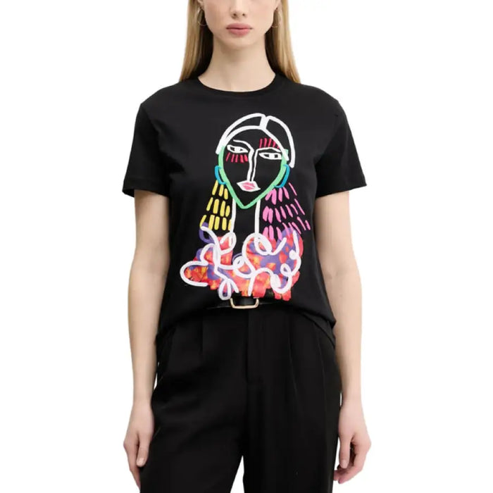Woman wearing a black T-shirt with a colorful abstract face design and Light Blue Jeans