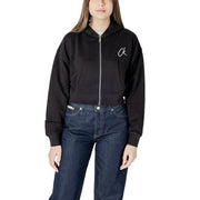 Woman wearing a black zip-up hoodie and blue jeans showcasing the Blue Cropped Zip Up Hoodie