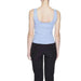 Woman in blue top and black pants modeling urban city style clothing by Jacqueline De Yong