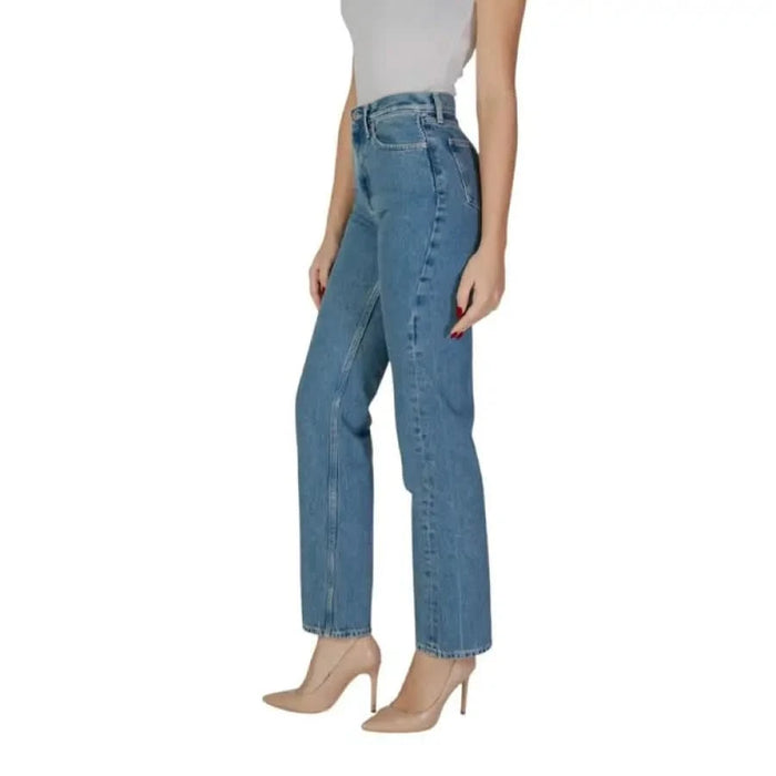 Woman in blue cotton Calvin Klein jeans paired with elegant nude heels