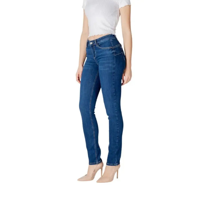 Woman wearing dark wash blue denim skinny jeans and heels standing confidently