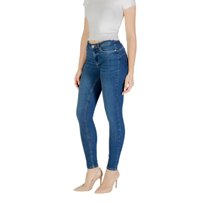 Woman wearing blue skinny jeans and nude heels, showcasing Women’s Blue Skinny Jeans