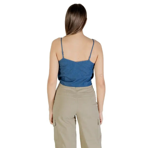 Woman wearing a blue tie front tank top and khaki cargo pants