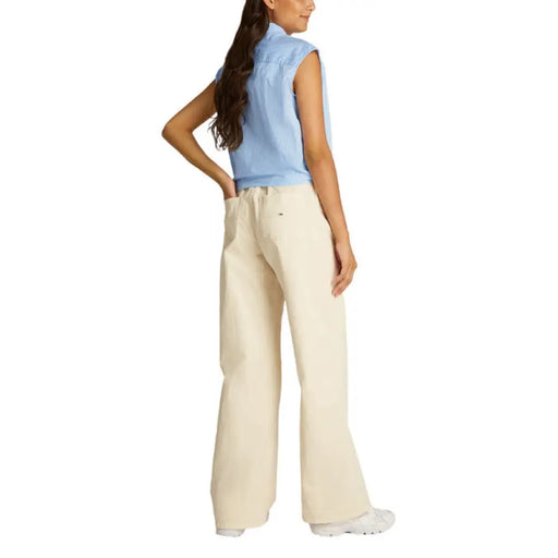 Woman wearing a blue sleeveless top and beige wide-leg pants for Woman in Blue and White Striped Tie Front Shirt