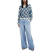 Woman wearing a blue and white crocheted sweater with wide-leg jeans fashion ensemble