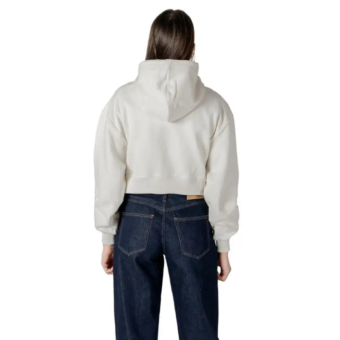 Woman wearing a cropped hoodie and jeans showcasing the Women Hooded Sweatshirt and Jeans product
