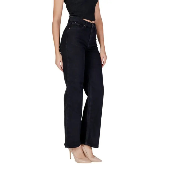 Woman wearing dark wash high-waisted wide-leg denim jeans full body shot