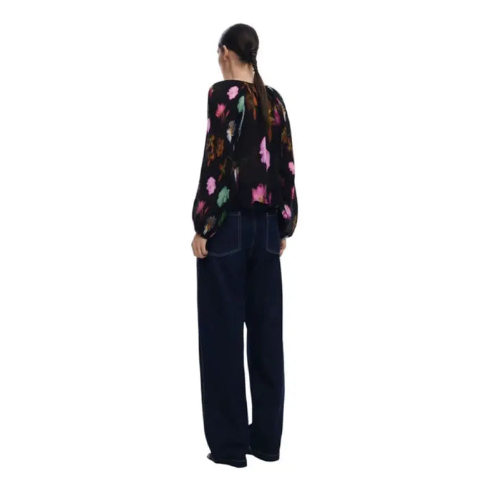 Woman wearing floral print balloon sleeve button down blouse and wide-leg jeans