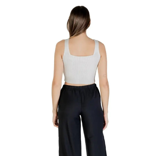 Woman wearing a gray cropped tank top and black pants for Womens Cropped Tank Top and Black Pants