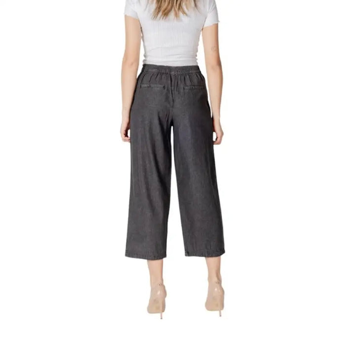 Woman styled in gray culottes and heels, showcasing Gray Cropped Pleated Pants