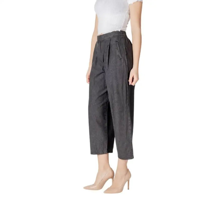 Woman in gray cropped pleated pants paired with nude heels for a chic outfit