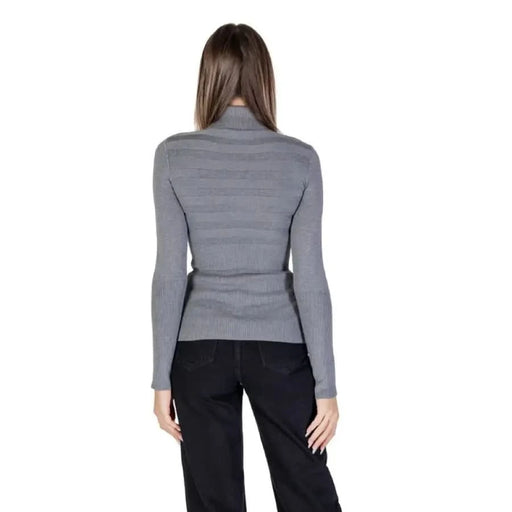Woman in gray turtleneck and black pants wearing Morgan De Toi Women’s Grey Turtleneck Sweater