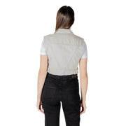 Woman wearing a light gray denim vest and black pants showcasing stylish casual attire