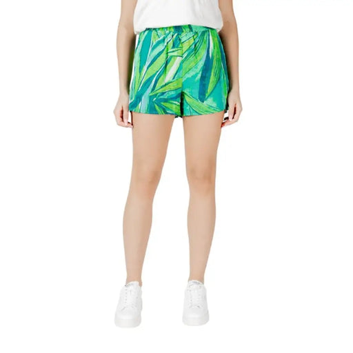Woman wearing stylish green leaf-patterned shorts from Women’s Green Leaf Patterned Shorts collection