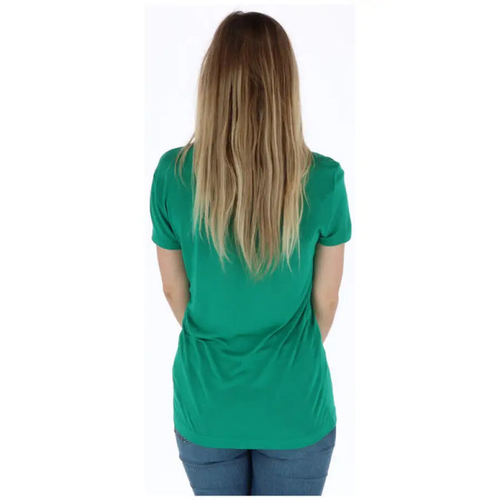 Woman wearing a green T shirt with pink lettering displayed in the product listing