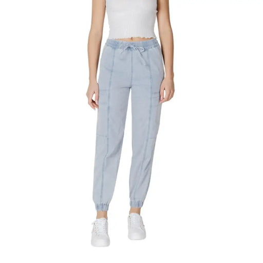 Woman wearing light blue drawstring jogger pants and white sneakers
