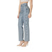 Woman wearing high waisted light blue denim jeans and nude heels posed stylishly