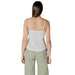 Woman in a light-colored camisole with white lace trim and green pants for women’s fashion