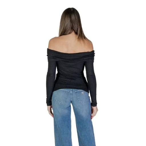 Woman wearing Jacqueline De Yong Black Knit Boat Neck Sweater and blue jeans