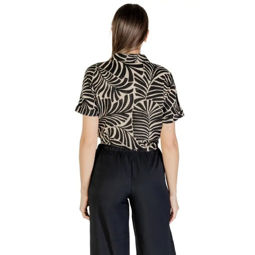Woman wearing a patterned tie-front shirt and dark pants, ideal for women’s fashion