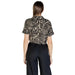 Woman wearing a patterned tie-front shirt and dark pants, ideal for women’s fashion