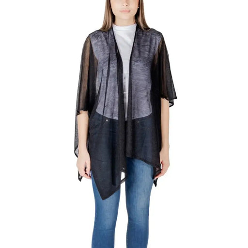 Woman wearing a sheer black cardigan and jeans from the Women’s Beige Cardigans and Poncho Collection