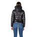 Woman wearing a shiny black hooded puffer jacket and blue jeans showcasing Women’s Black Hooded Puffer Jacket