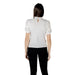 Woman wearing a white blouse with lace trim and black pants for the women’s fashion collection