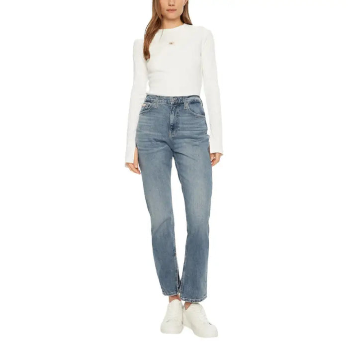 Woman wearing a white long-sleeved shirt and blue denim jeans for women’s fashion display