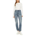 Woman wearing a white long-sleeved shirt and blue denim jeans for women’s fashion display
