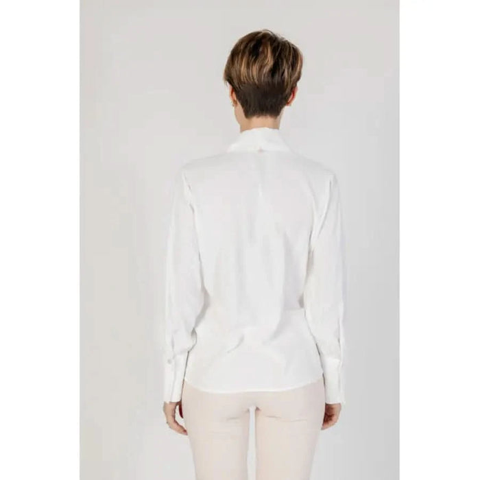 Woman in white shirt and light pants modeling Rinascimento Women’s White V-Neck Long Blouse