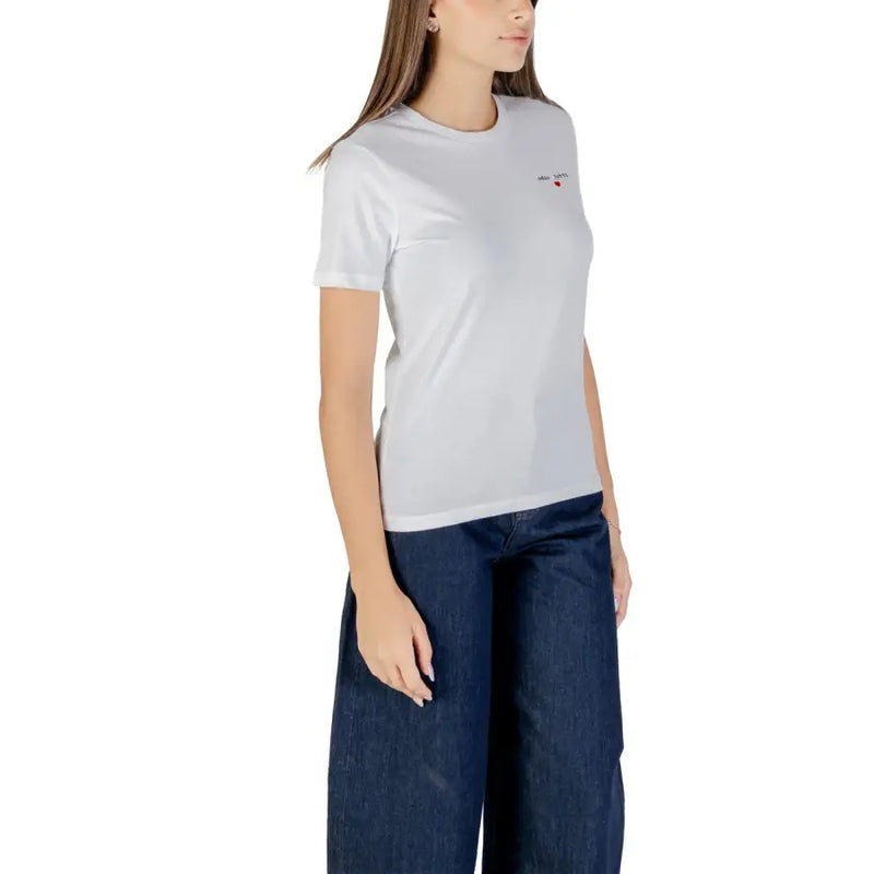 Woman wearing a white short sleeve round neck cotton T shirt and wide-leg dark blue jeans
