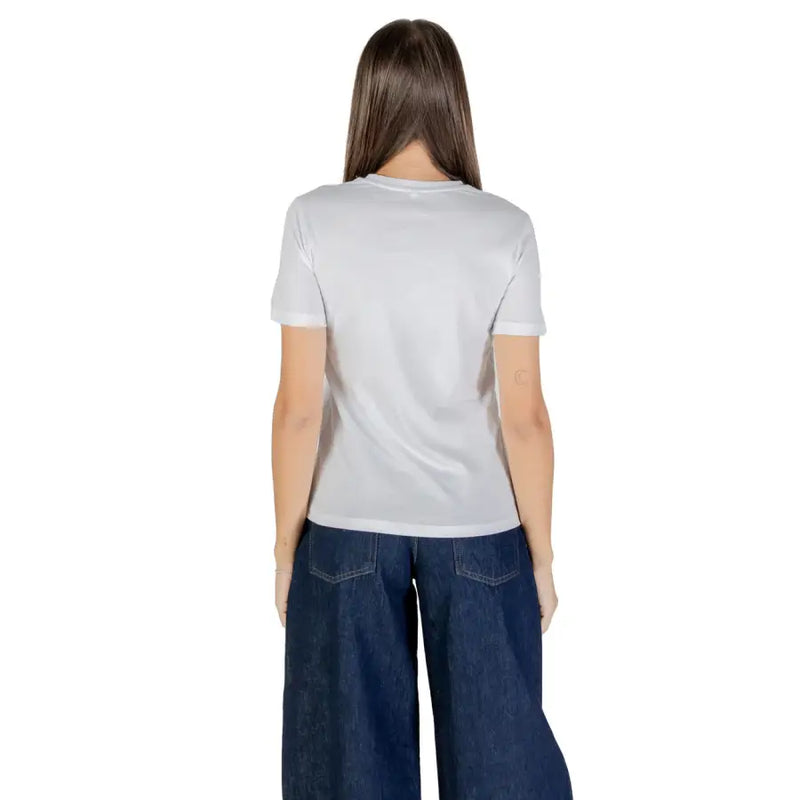 Woman wearing a white short sleeve round neck cotton t-shirt and wide-leg dark blue jeans