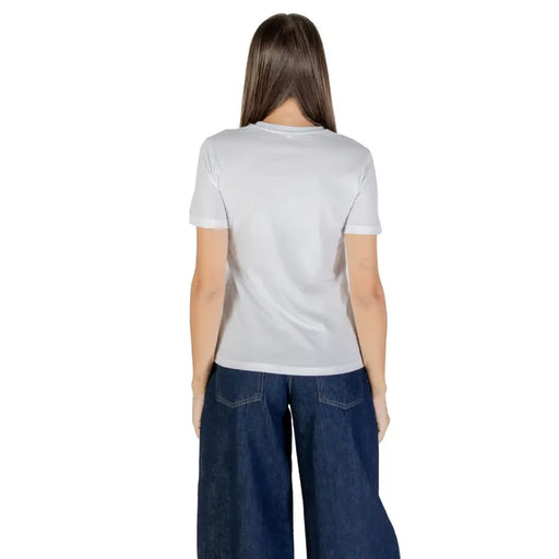 Woman wearing a white short sleeve round neck cotton t-shirt and wide-leg dark blue jeans