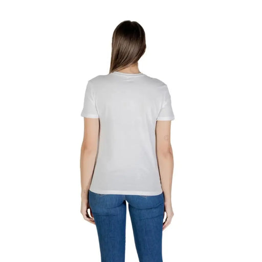 Woman wearing a white graphic tee and jeans showcasing casual fashion style